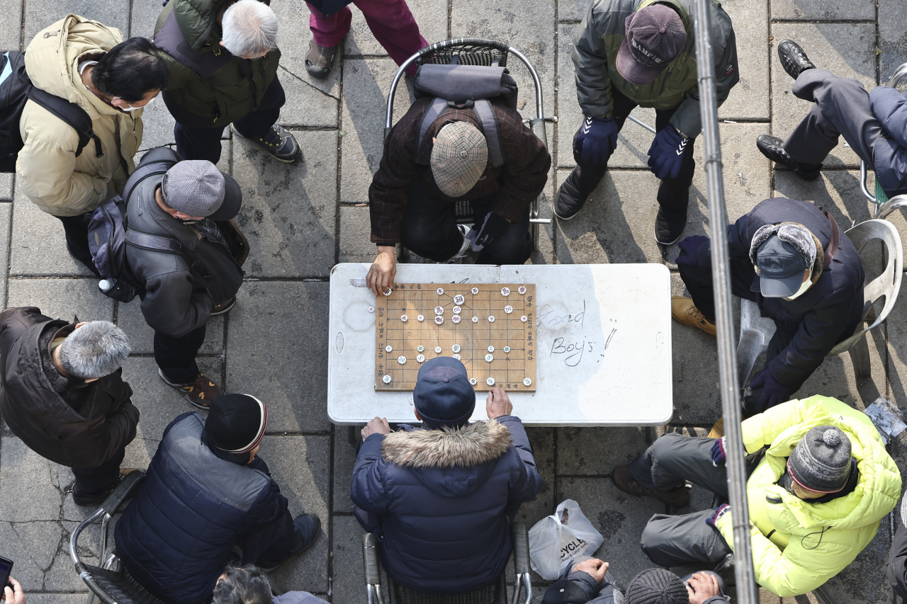 A group of older people play janggi, or Korean chess, near Tapgol Park in Jongno-gu, central Seoul on Wednesday. (Yonhap)
