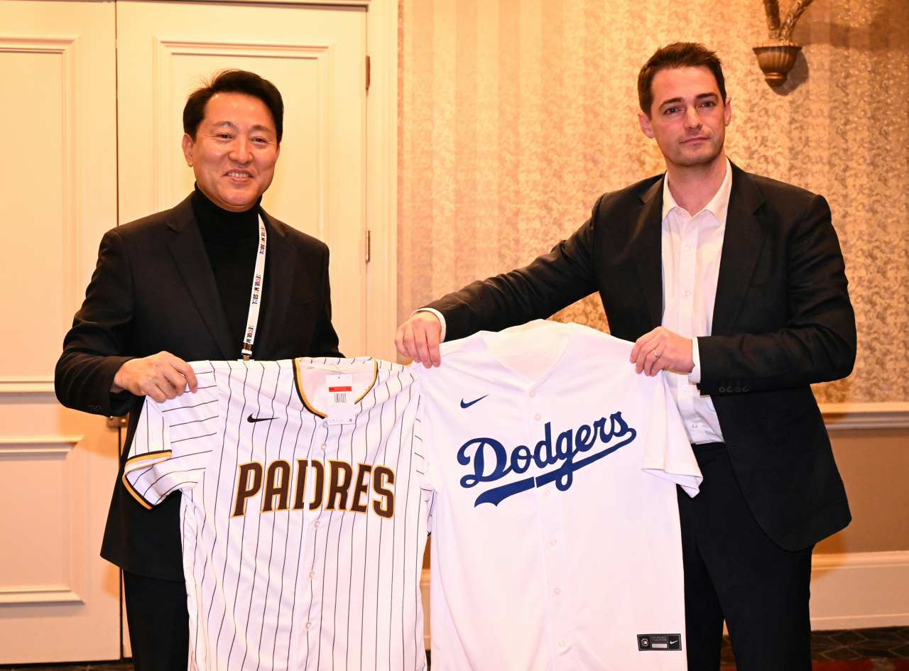 Seoul Mayor Oh Se-hoon(left) poses for a photo holding the uniforms of the San Diego Padres and the Los Angeles Dodgers, with Charlie Hill, Major League Baseball's vice president of international strategy, after a meeting at Caesars Palace Hotel in Las Vegas on Tuesday. (Seoul Metropolitan Government)
