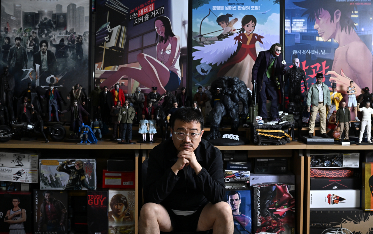 Yeon Sang-ho poses for photos after an interview at his studio in Mapo-gu, Seoul, September 2023. (Im Se-jun/The Korea Herald).