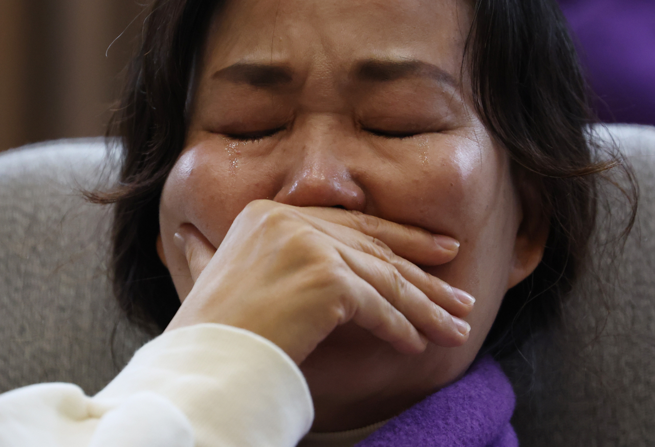 A bereaved family member of the Itaewon crowd crush victim in October 2022 sheds tears upon the passage of the special bill to launch a renewed probe to reveal the root cause of the disaster and compensate victims on Jan. 9. (Yonhap)