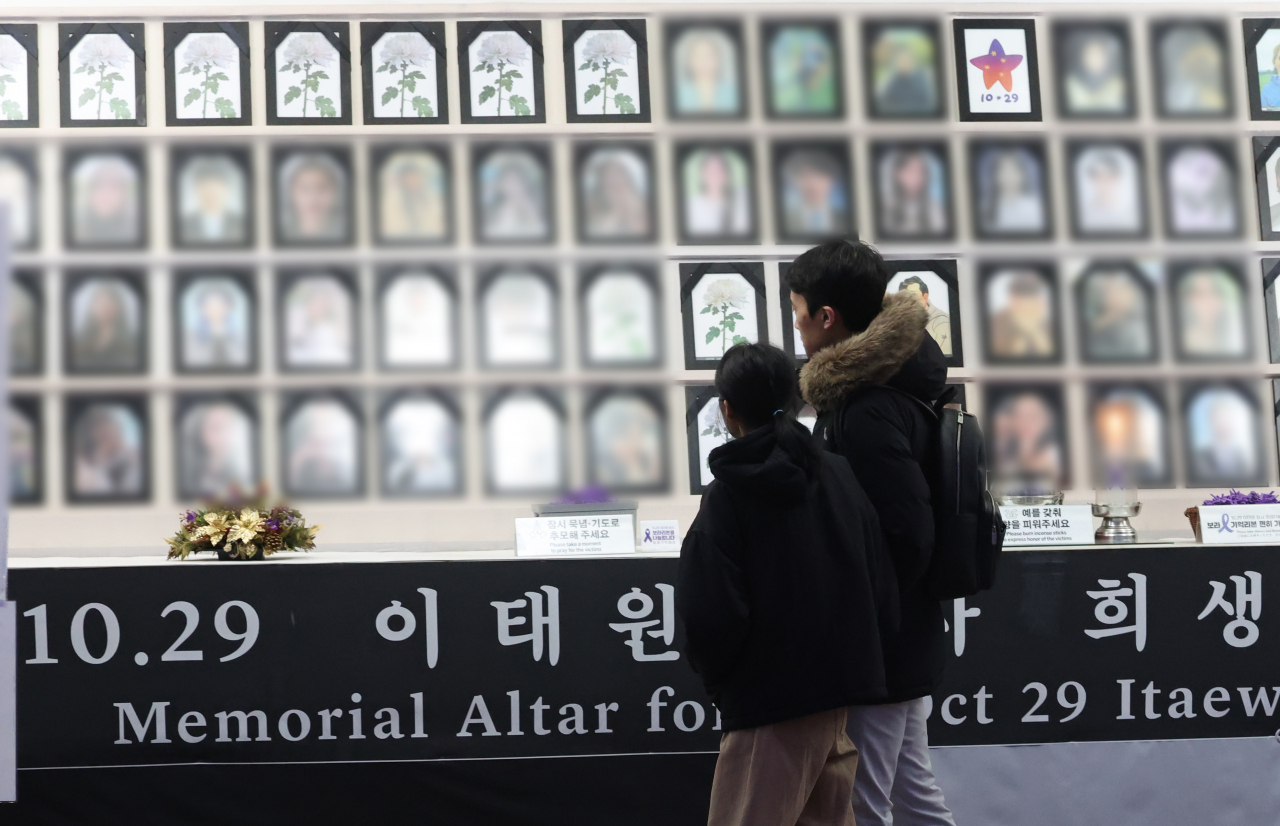 Pedestrians walk along a memorial altar in memory of the victims of the Itaewon crowd crush in October 2022 in Seoul on Tuesday. (Yonhap)