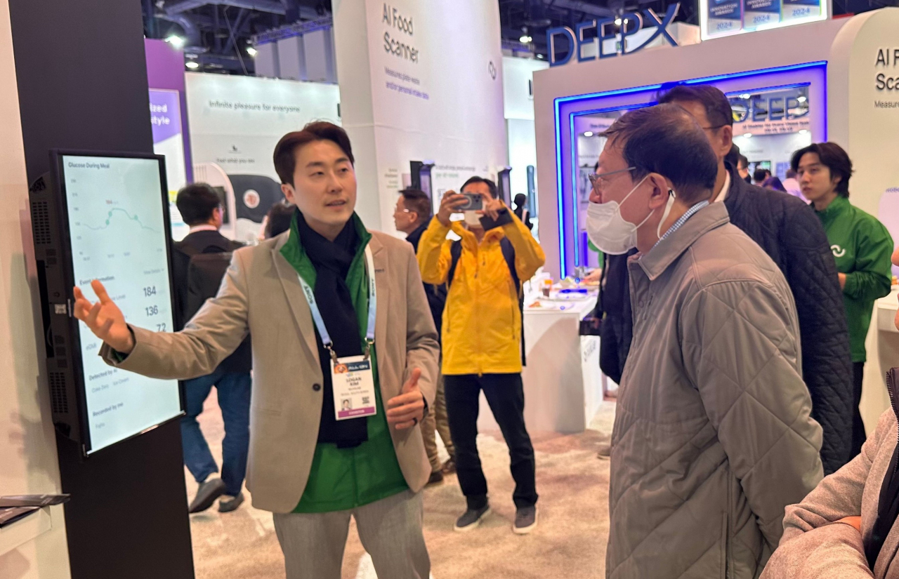 GS Group Chairman Huh Tae-soo (right) looks around the exhibition booth of Nuvilab at the CES 2024 in Las Vegas on Tuesday. (GS Group)