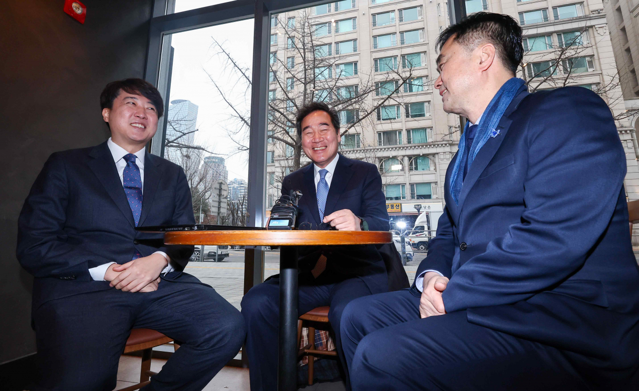 The former leaders of South Korea’s two main political parties -- Lee Jun-seok (left) and Lee Nak-yon (center) -- and Rep. Kim Jong-min (right) speak at a Starbucks near the National Assembly in Yeouido, central Seoul, on Sunday. (Yonhap)
