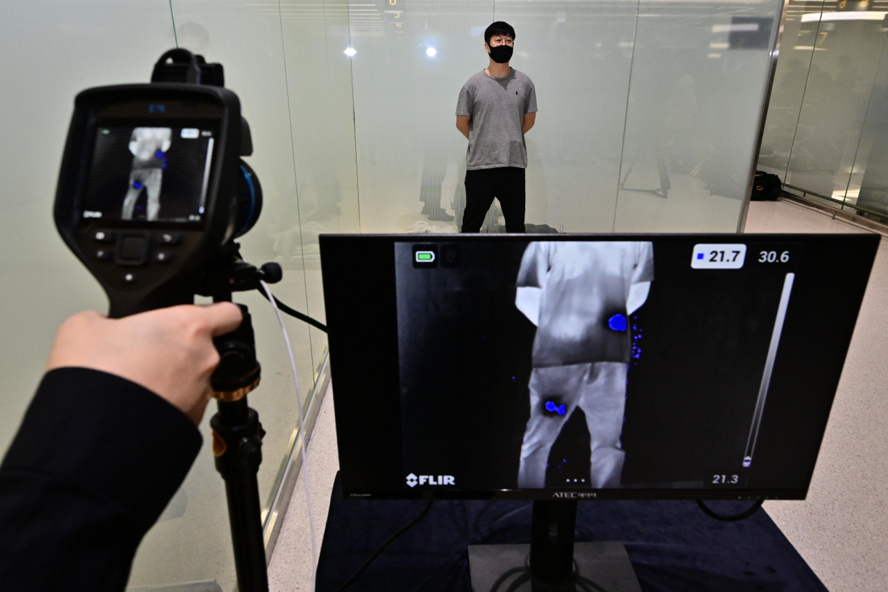 An official from the Korea Customs Service demonstrates how the body heat scanner changes color within seconds when drug possession is recognized in the body during a press briefing on drugs seized in 2023 held at Incheon Airport’s Terminal 1, Wednesday. (Joint Press Corp.)
