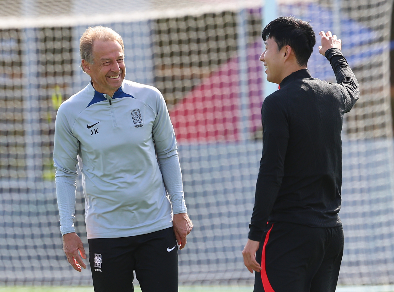 South Korea head coach Jurgen Klinsmann (left) and captain Son Heung-min chat during a training session for the Asian Football Confederation Asian Cup at Al Egla Training Site in Doha on Wednesday. (Yonhap)