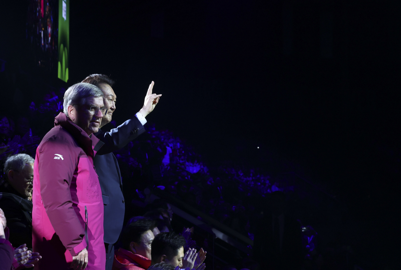 President Yoon Suk Yeol (right) and Thomas Bach, president of the International Olympic Committee, wave to the audience during the opening ceremony for the Winter Youth Olympics held in Gangneung, some 160 kilometers east of Seoul, on Friday. (Yonhap)