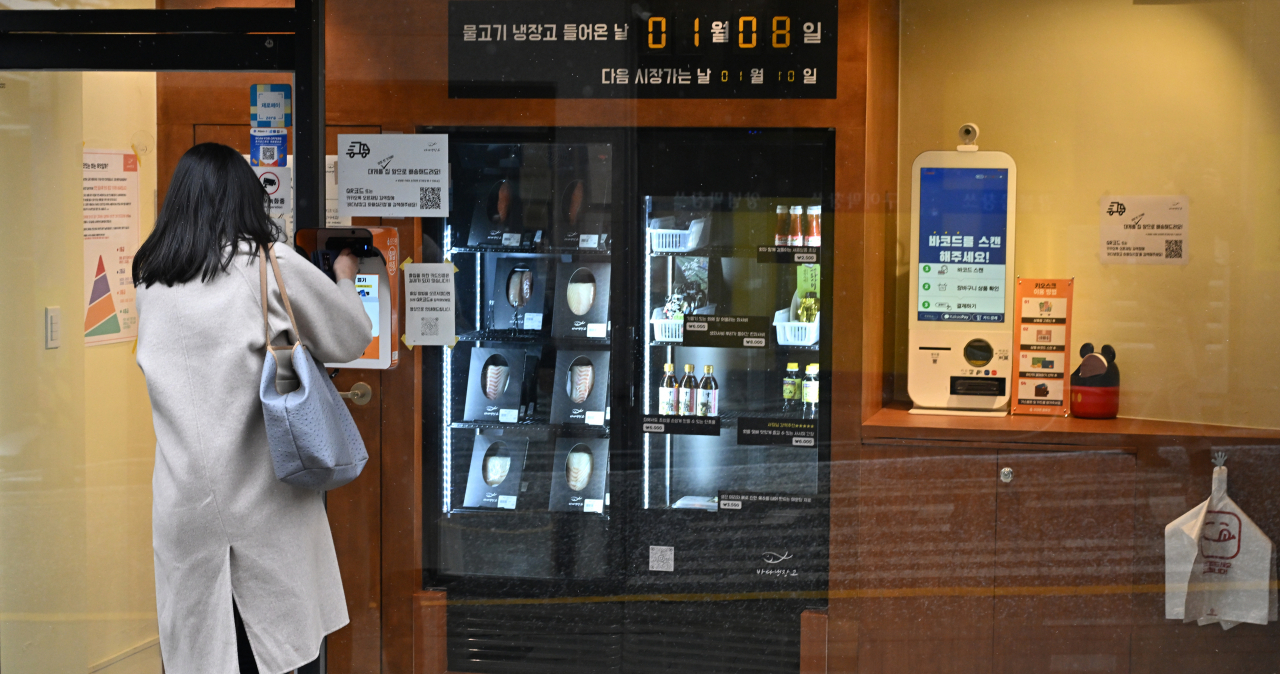 A customer enters the unstaffed sashimi store, Sea Fridge, in Sangwangsimni, Seoul, through credit card authentication. (Im Se-jun/The Korea Herald)