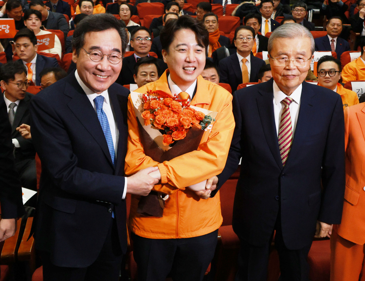 Former Prime Minister Lee Nak-yon, right, and former People Power Poarty Interim Leader Kim Chong-in, left, shakes hands with ex-People Power Party leader Lee Jun-seok as they congratulate him on launching his new political party in a celebration held at the National Assembly on Saturday. (Yonhap)