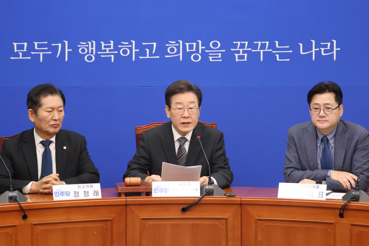 Main opposition leader Lee Jae-myung (center) speaks during a party meeting at the National Assembly on Friday. (Yonhap)