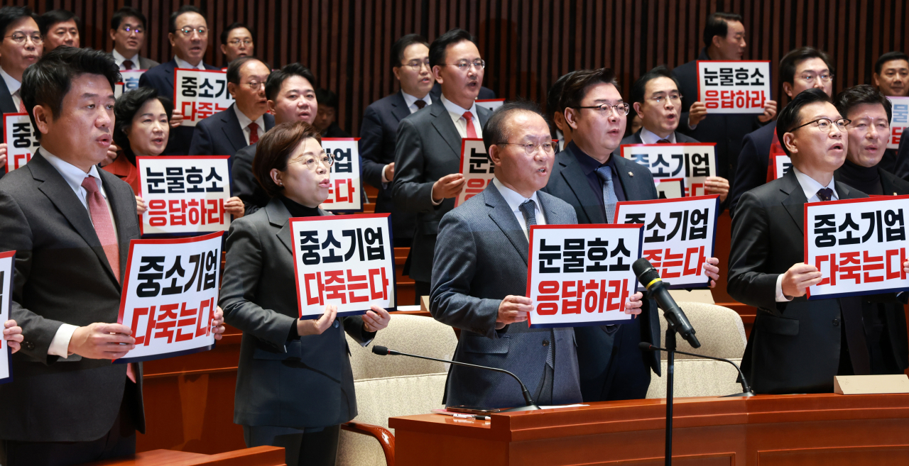 People Power Party lawmakers chant as they call for an extension of the grace period of the Serious Accident Punishment Act for small businesses. The lawmakers are holding signs that read ″Small businesses will all be gone,″ and ″Respond to small businesses' pleas,″ during the party's general meeting on Thursday at the National Assembly in western Seoul. (Newsis)