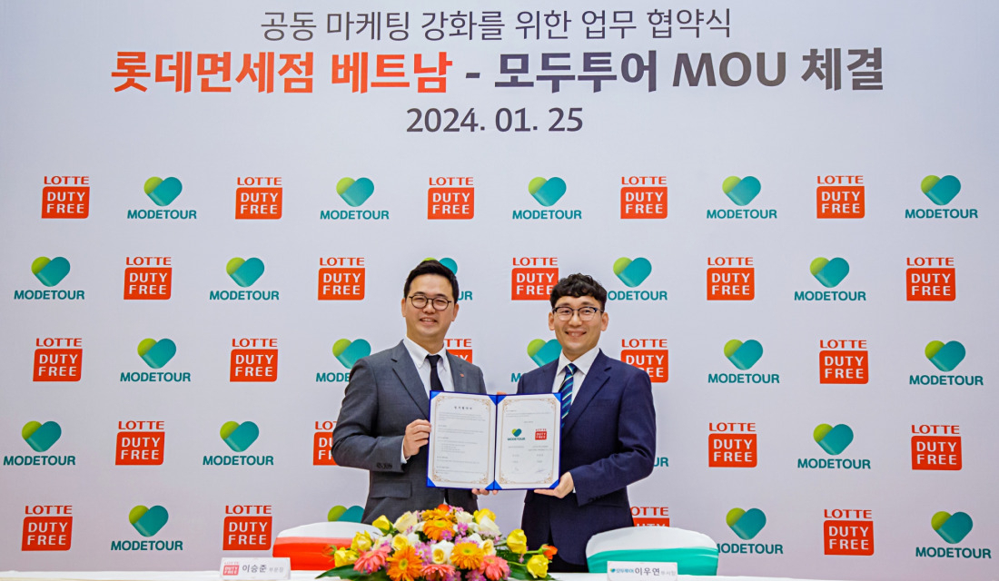 Lee Seung-jun of Lotte Duty Free’s overseas business department and Lee Woo-Yeon of Modetour's Southeast Asia business division pose for a photo after a signing event at the Pullman Danang Beach Resort, Vietnam on Thursday. (Lotte Duty Free)