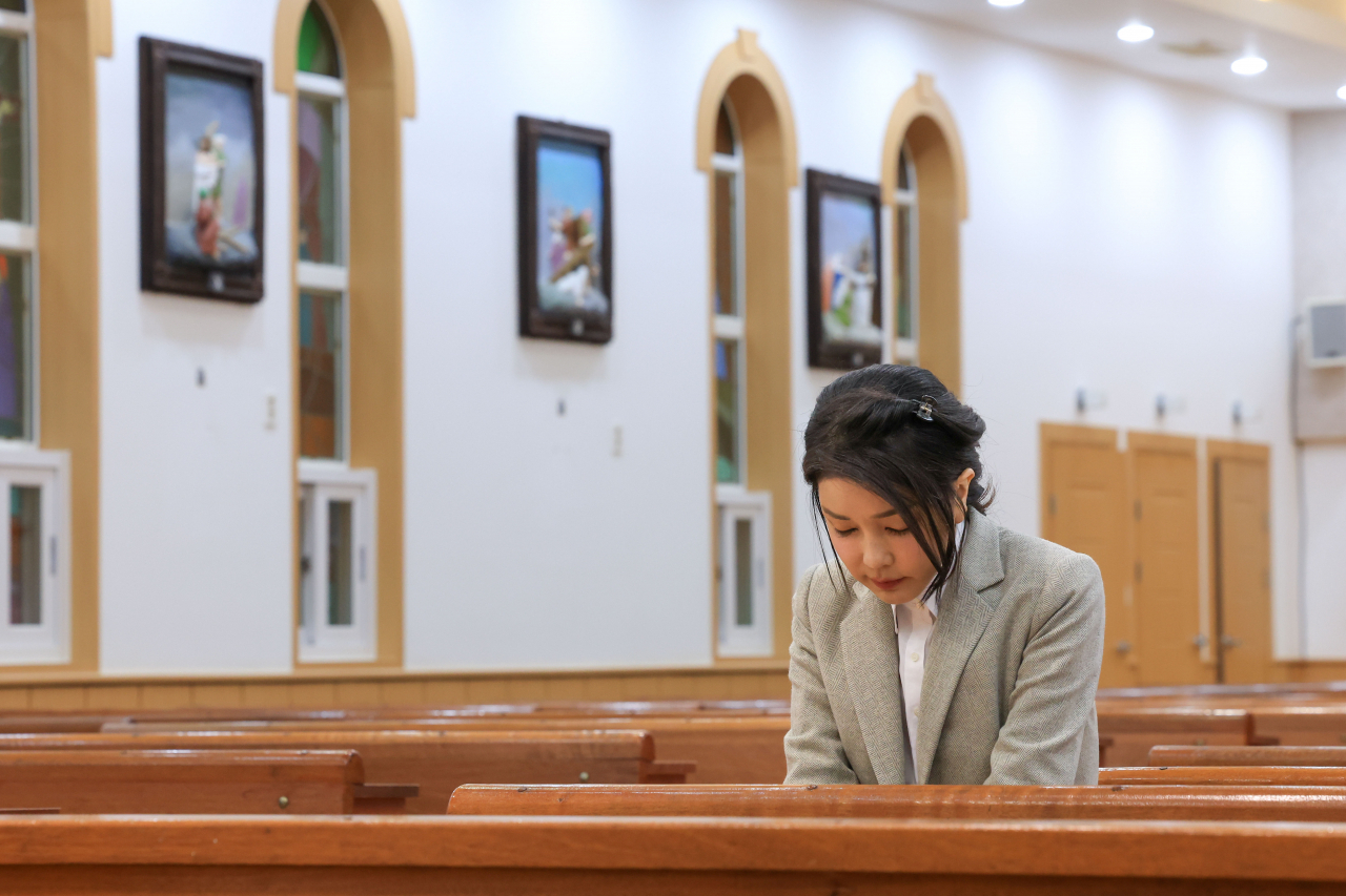 This photo shows first lady Kim Keon Hee sending a prayer at a Catholic church in Sorokdo island in South Jeolla Province during her visit there in November. (Presidential office)