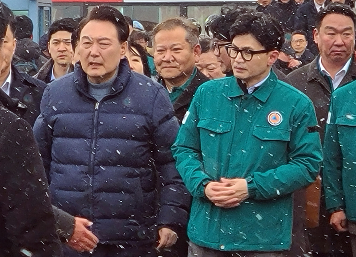 President Yoon Suk Yeol (left), alongside Han Dong-hoon (right), interim leader of the ruling People Power Party, visits the site of a fire at a traditional market in Seocheon, South Chungcheong Province, central South Korea on Tuesday. (Yonhap)