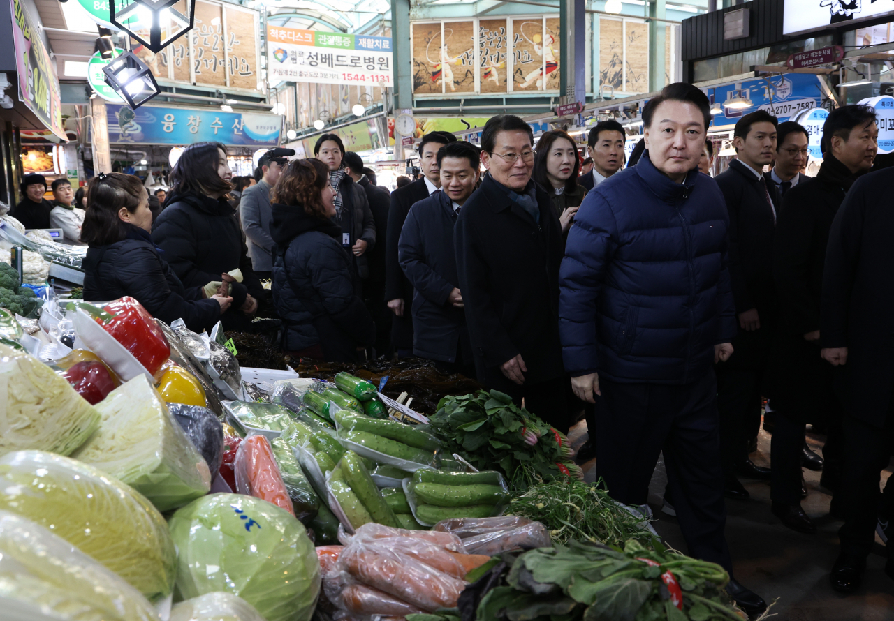 President Yoon Suk Yeol (fourth from right) and presidential staff visit Uijeongbu Jeil Market in Uijeongbu, Gyeonggi Province, on Thursday. (Yonhap)