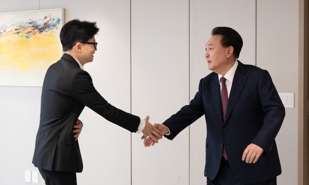 President Yoon Suk Yeol (right) shakes hands with Han Dong-hoon, interim leader of the ruling People Power Party, during their luncheon meeting at the presidential office in Seoul on Monday in this photo provided by the presidential office. (Yonhap)