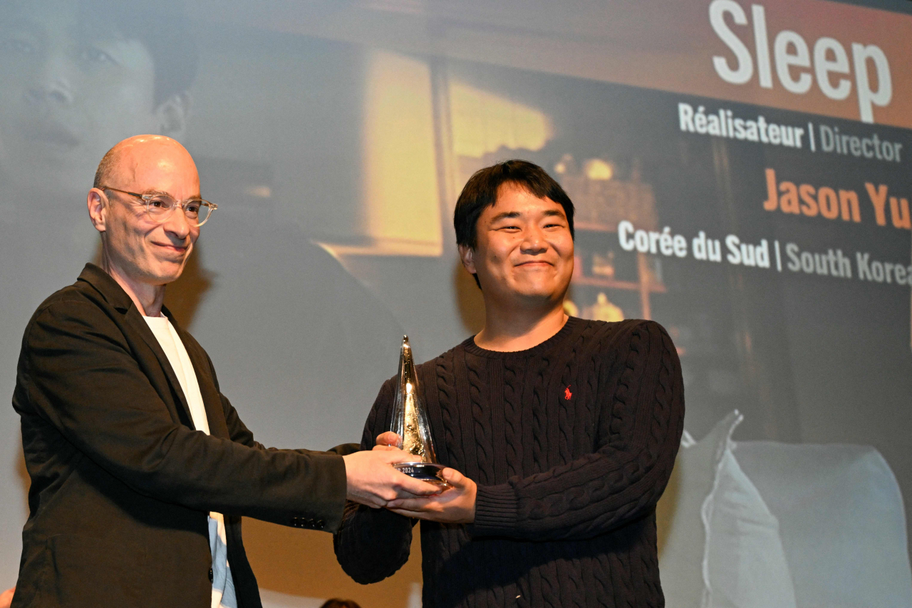 South Korean director Jason Yu (right) poses with French author, journalist and director, president of the feature film jury, Bernard Werber after winning the Grand prize for the film 