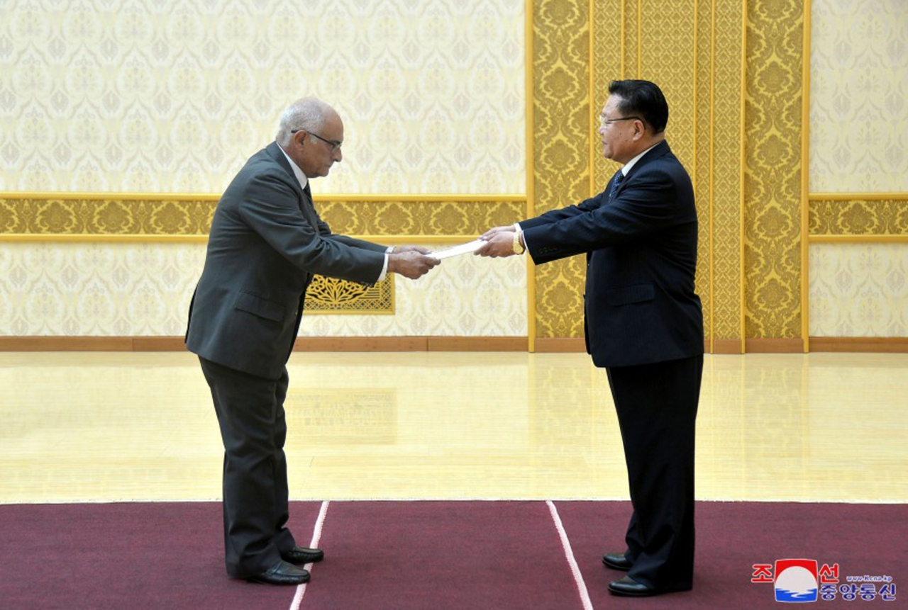 This photo, published on Thursday, shows Choe Ryong-hae (right), chairman of the Standing Committee of the Supreme People's Assembly, receiving a letter of credence from Cuba's new ambassador Wednesday. (KCNA)
