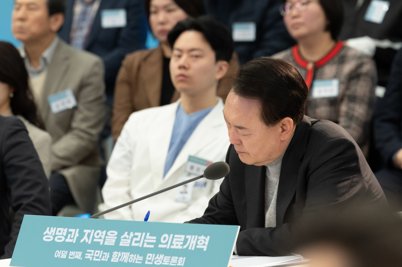 President Yoon Suk Yeol (front, right) takes note during a public debate that touched upon the issue of medical reform at the Seoul National University Bundang Hospital in Seongnam, Gyeonggi Province, on Thursday. (Presidential office)