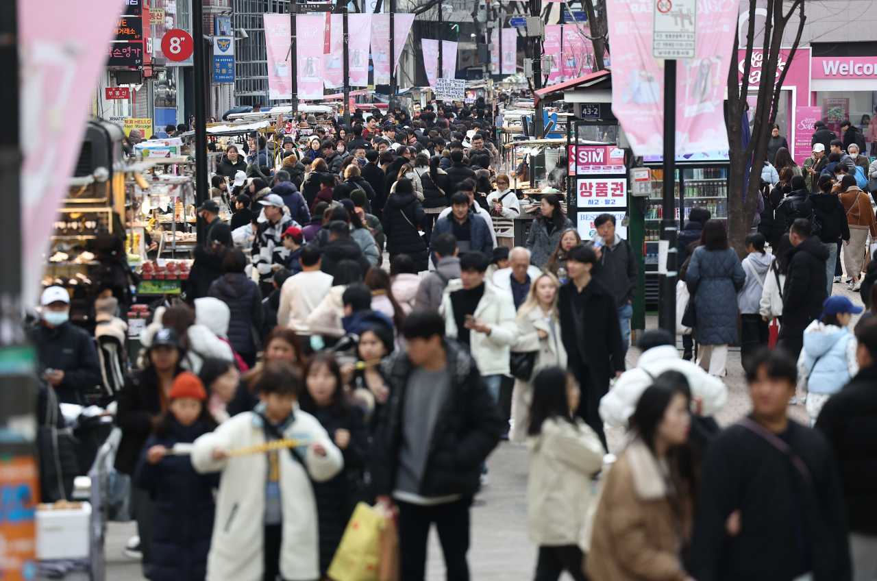 Streets of Seoul's Myeongdong bustle with both locals and tourists on Sunday afternoon. (Yonhap)