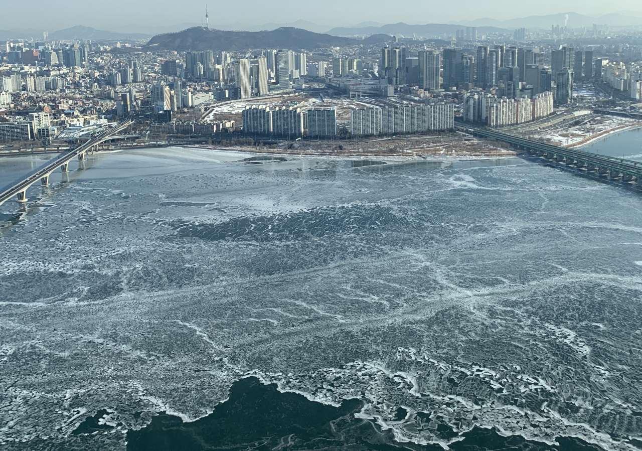 These days, the Han River, when it freezes over, forms only a thin layer of ice, as captured in this 2021 photo. (The Korea Herald)