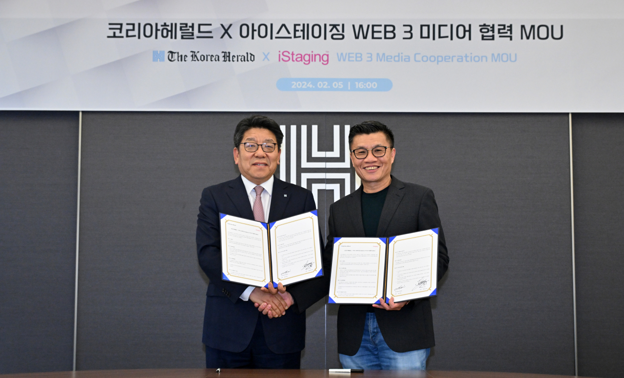 The Korea Herald CEO Choi Jin-young (left) and iStaging Founder and CEO Johnny Lee pose for a photo after a signing event at The Korea Herald's headquarters in Yongsan, central Seoul, Monday. (Lim Se-jun/The Korea Herald)