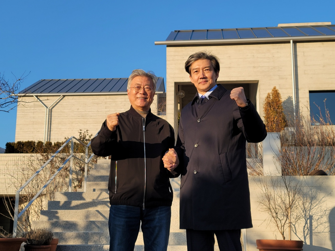 Ex-Justice Minister Cho Kuk, right, poses for a photo next to former President Moon Jae-in near Moon's residence in a rural village in Pyeongsan-gun, South Gyeongsang Province on Monday. (Yonhap)
