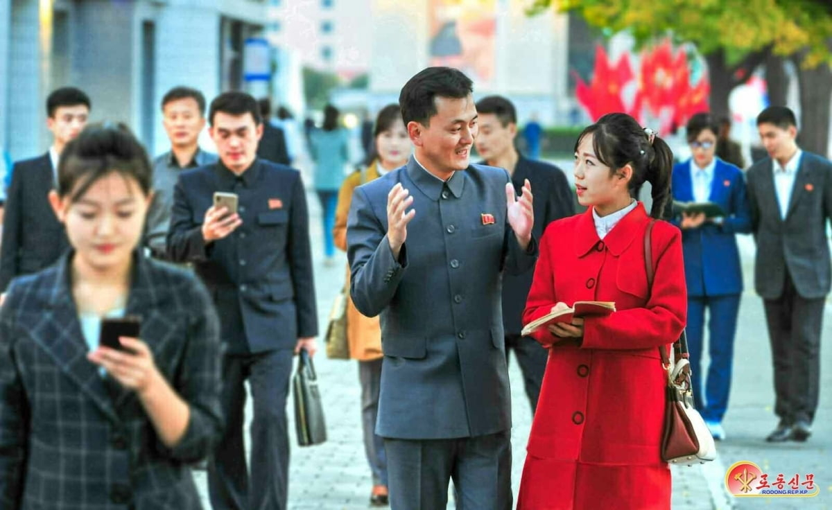 This photo distributed by North Korea's Rodong Sinmun shows North Koreans walking and using mobile phones. (Rodong Sinmun)