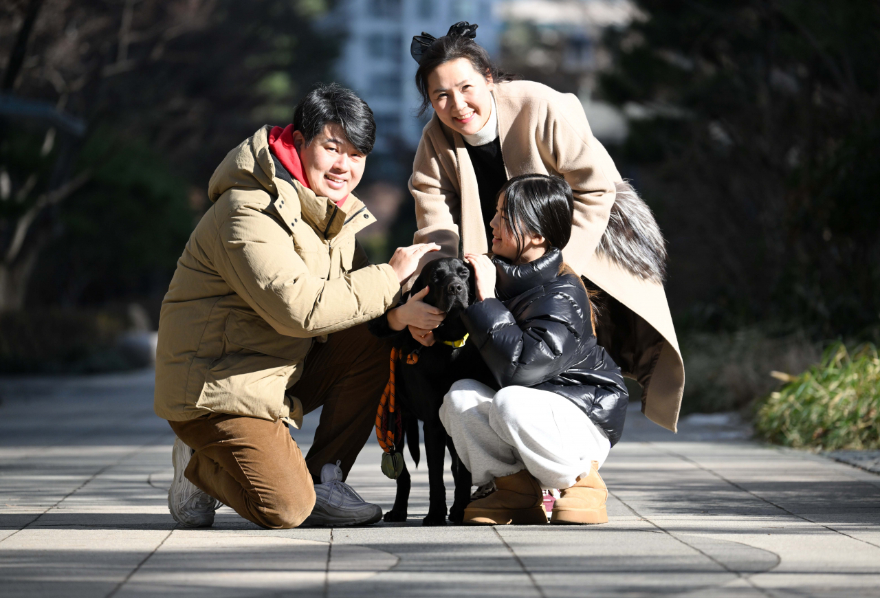 Family members pet Parang on the pavement in an apartment complex. (Lee Sang-sub/The Korea Herald)