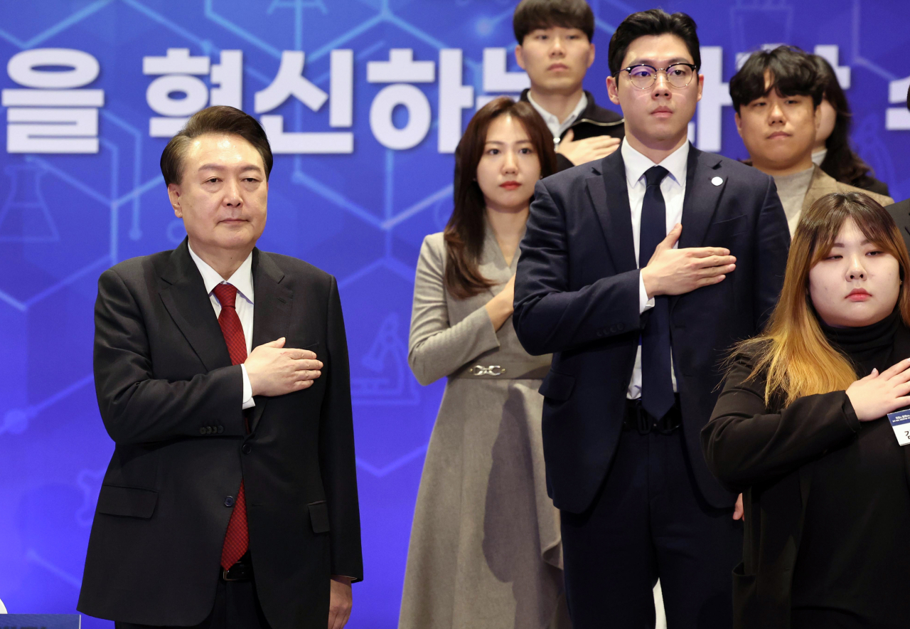 President Yoon Suk Yeol (left) salutes to the national flag with participants in the 12th session of the public debate to discuss South Korea's policy agenda held in Daejeon on Friday. (Pool photo via Yonhap)