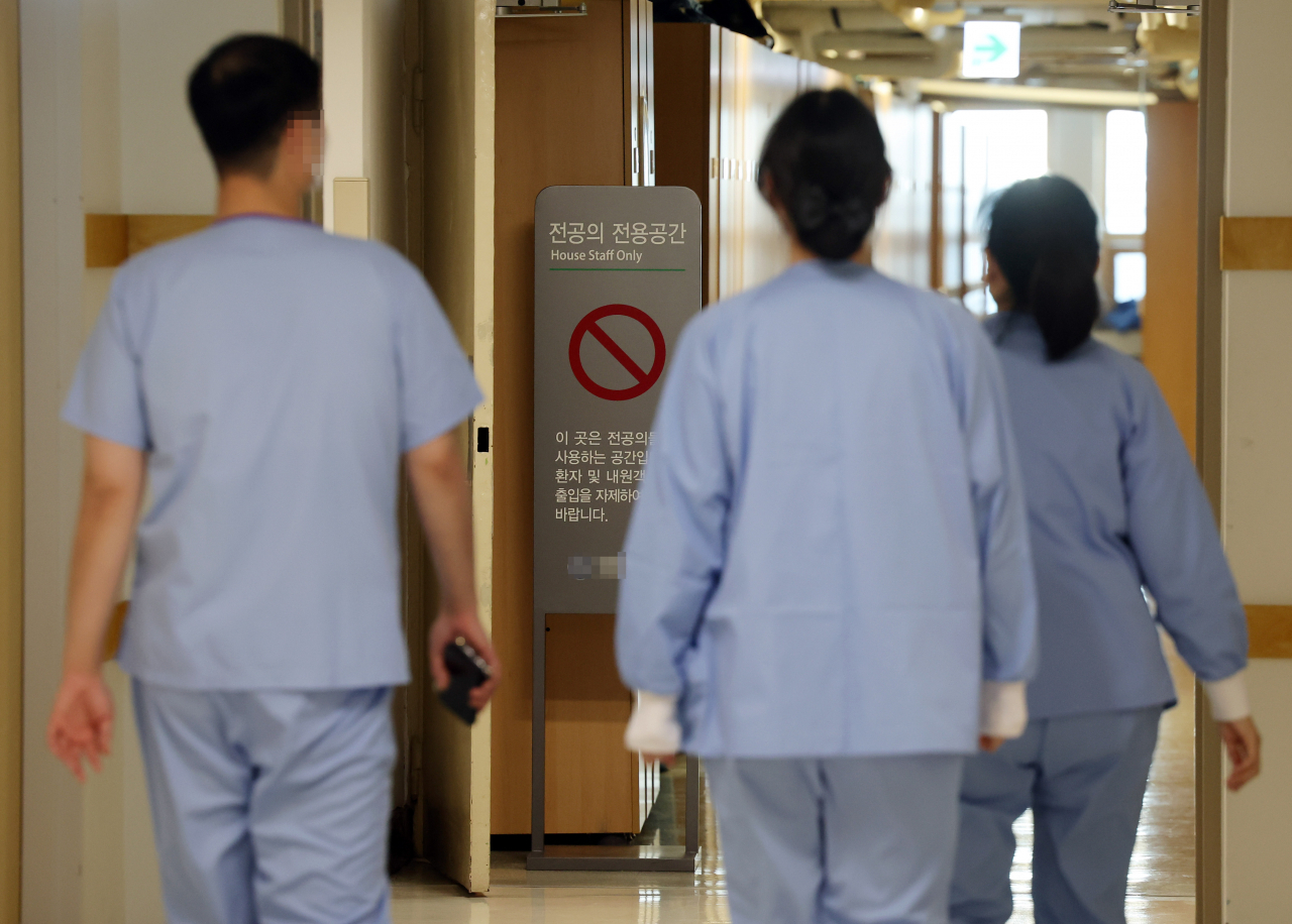 Doctors walk at a hospital in Seoul on Friday. (Yonhap)
