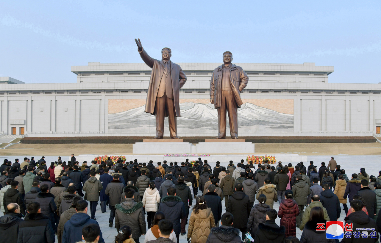North Koreans pay respect at the statues of former late leaders Kim Il-sung and Kim Jong-il in Pyongyang on Friday. (KCNA)