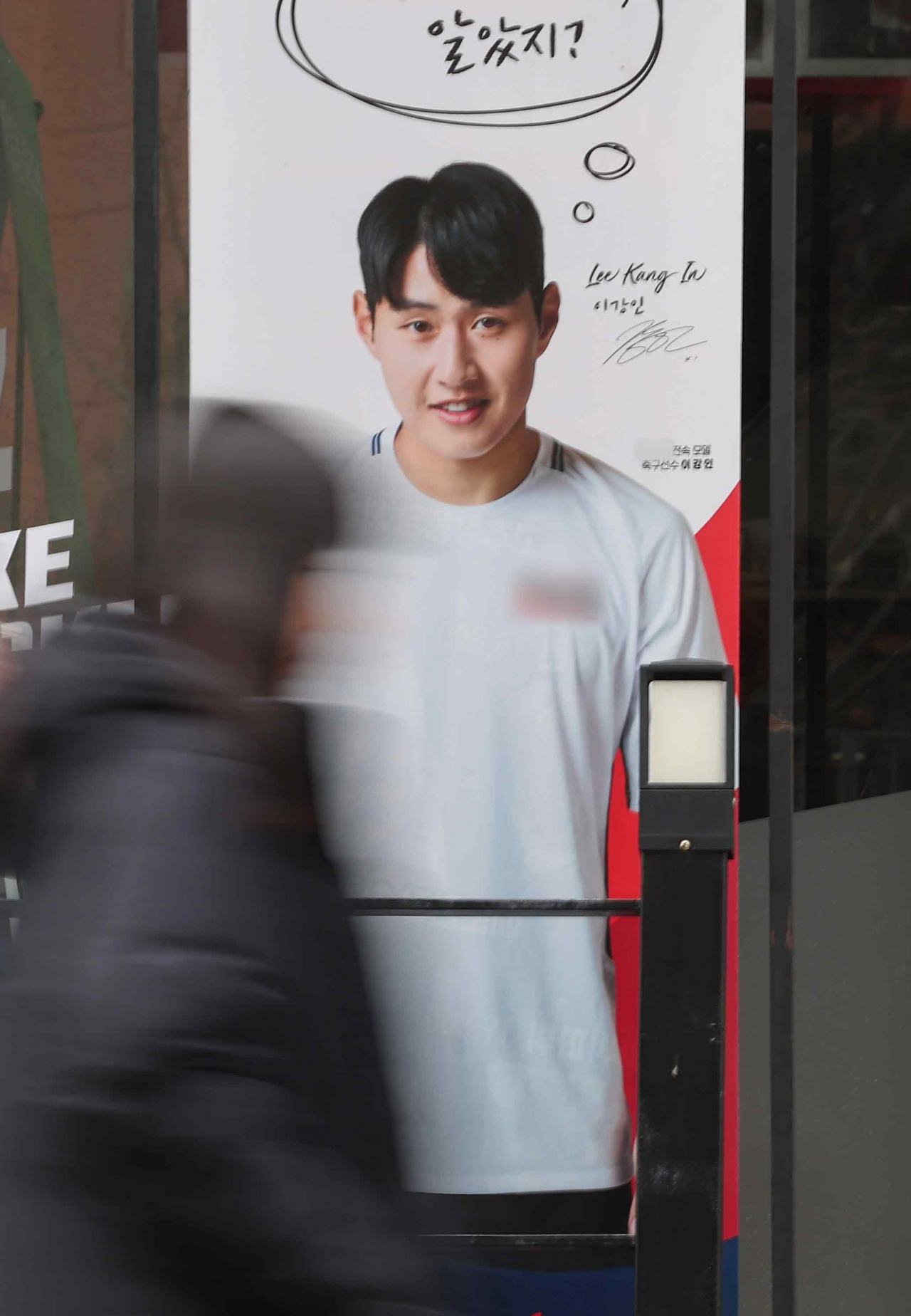 A pedestrian passes by a promotional poster featuring Lee Kang-in for the Samsung Galaxy S24 at a KT branch in Seoul, Sunday. (Yonhap)