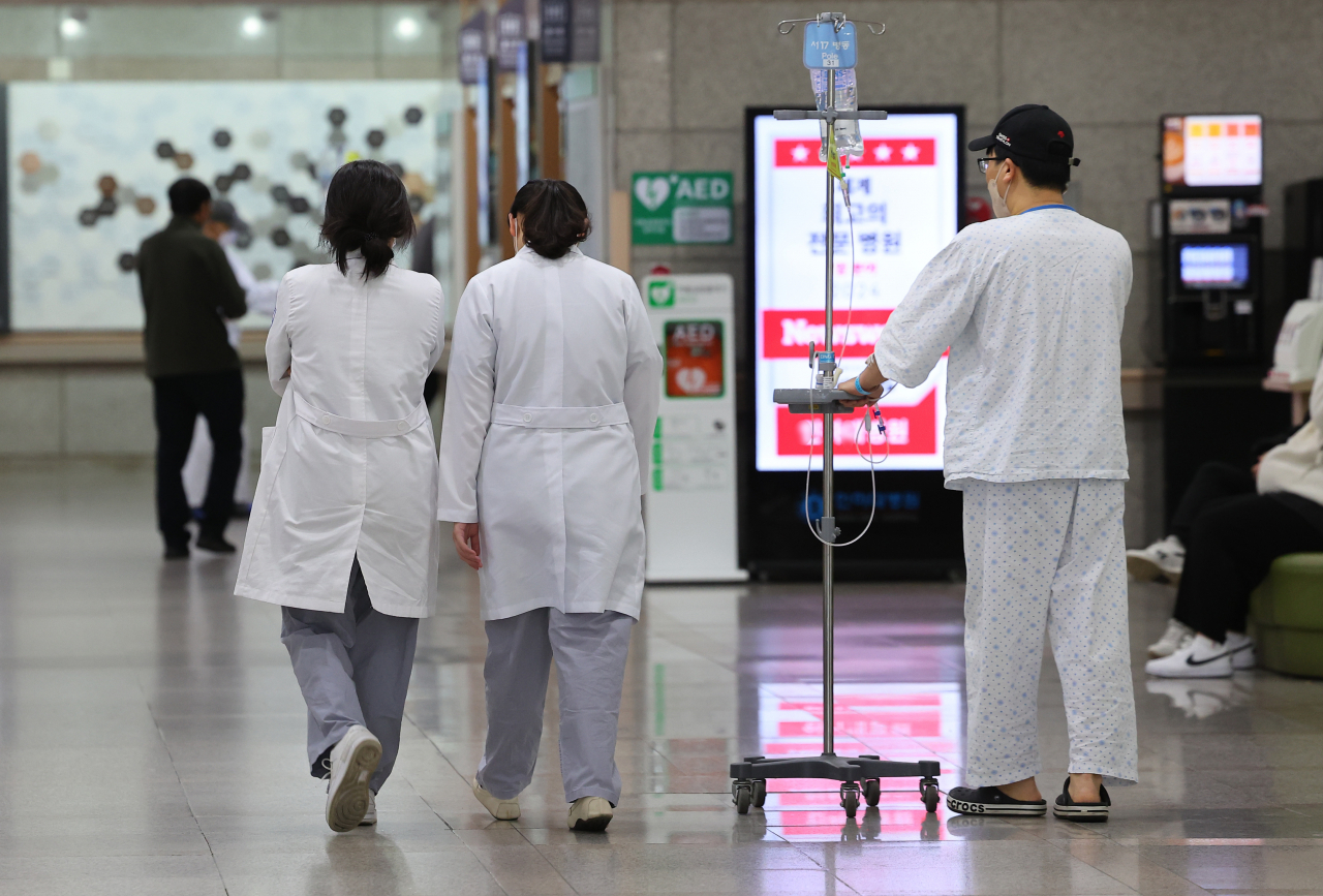 Doctors and patients walk inside a hospital in Incheon on Tuesday, after more than 6,400 doctors submitted collective resignation letters to protest the government's plan to boost the medical school quota next year. (Yonhap)