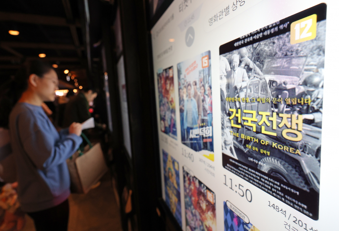 A moviegoer selects the film on a ticket vending machine at a local multiplex cinema in Seoul. (Yonhap)