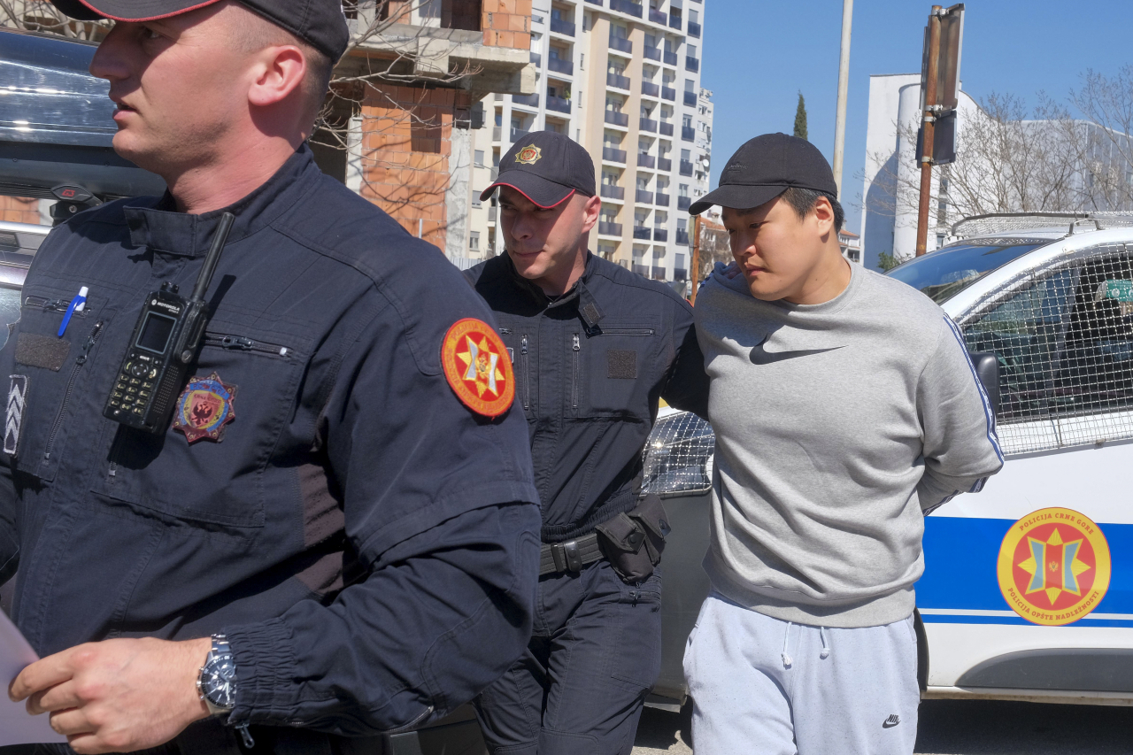 Police escort Terraform Labs founder Kwon Do-hyung in Montenegro's capital Podgorica on March 24 last year. (AP-Yonhap)