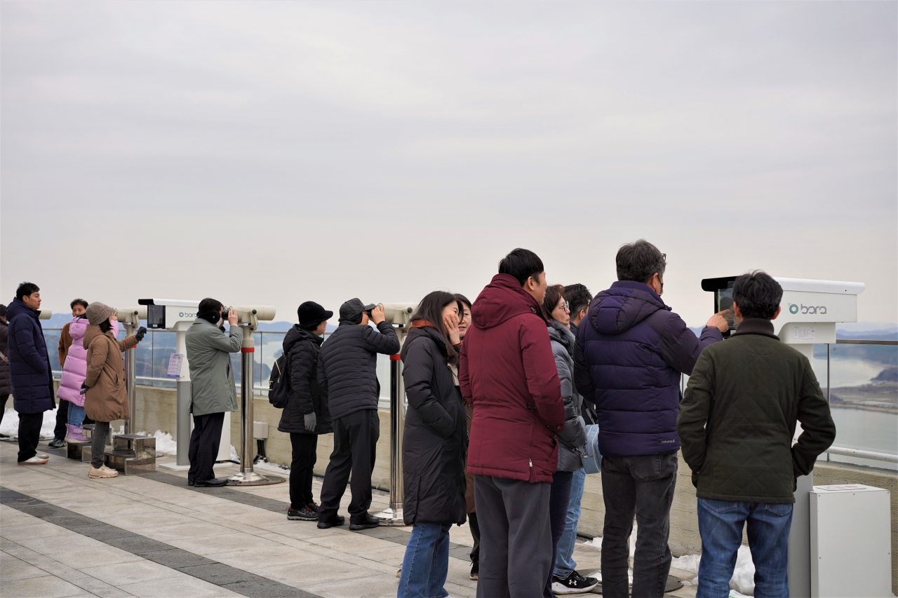 Tourists take a look of North Korea through the telescopes at Aegibong Peace Ecopark's Jogang Observatory in Gimpo, Gyeonggi Province, on Saturday. (Lee Si-jin/The Korea Herald)