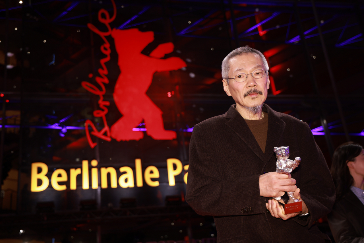 Hong Sang-soo poses with the Silver Bear Grand Jury Prize for “A Traveler’s Needs” after the award ceremony during the 74th Berlin International Film Festival in Berlin, Saturday. (EPA-Yonhap)
