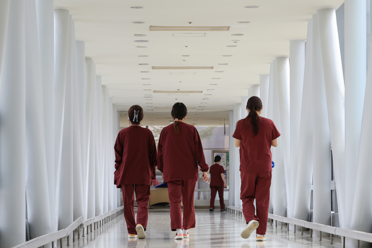 Nurses walk at a university hospital in Seoul on Tuesday after the government announced a pilot project to adjust the scope of nurses' duties. (Yonhap)