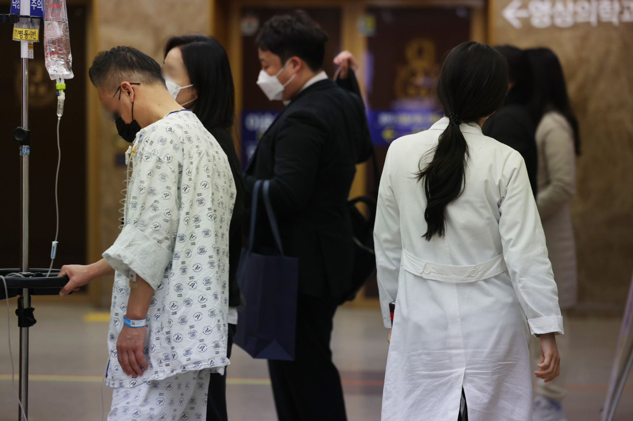 A patient and a doctor move about a hospital in Seoul on Tuesday. (Yonhap)