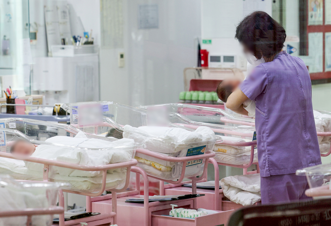 A worker cares for newborns at a postpartum care center in Seoul, Wednesday. (Joint Press Corps)
