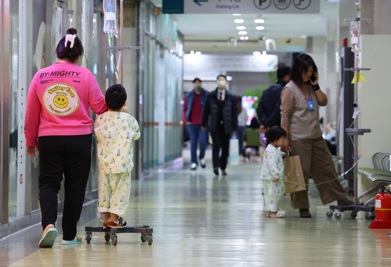 A child patient walks down the corridor with a guardian at a hospital in Incheon, Wednesday. (Yonhap)