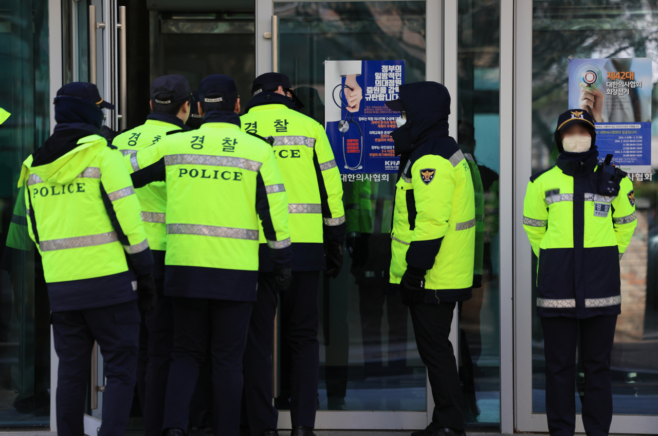 Police officers control the entrance to the Korean Medical Association Hall in Yongsan, Seoul, Friday, as police launch a criminal investigation into officials of the association accused of violating medical laws. (Yonhap)