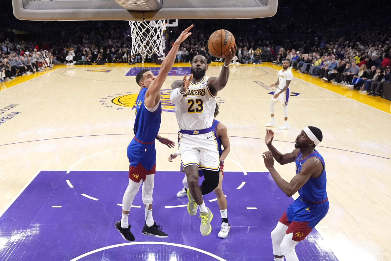 Los Angeles Lakers forward LeBron James (23) scores as Denver Nuggets forward Michael Porter Jr., defends, becoming the first NBA player to reach 40,000 points in a career, during the first half of an NBA basketball game Saturday in Los Angeles. (AP Photo-Yonhap)