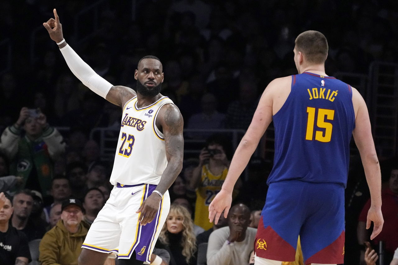 Los Angeles Lakers forward LeBron James, left, gestures as Denver Nuggets center Nikola Jokic watches during the second half of an NBA basketball game Saturday in Los Angeles. (AP-Yonhap)
