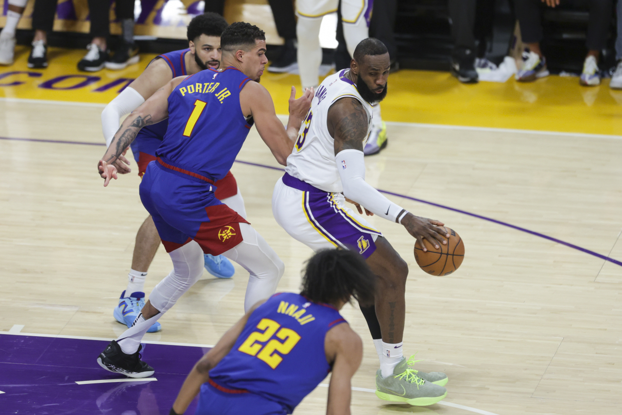 Los Angeles Lakers forward LeBron James (23) works around Denver Nuggets' Michael Porter Jr. (1) before shooting during the first half of an NBA basketball game Saturday in Los Angeles. (AP-Yonhap)