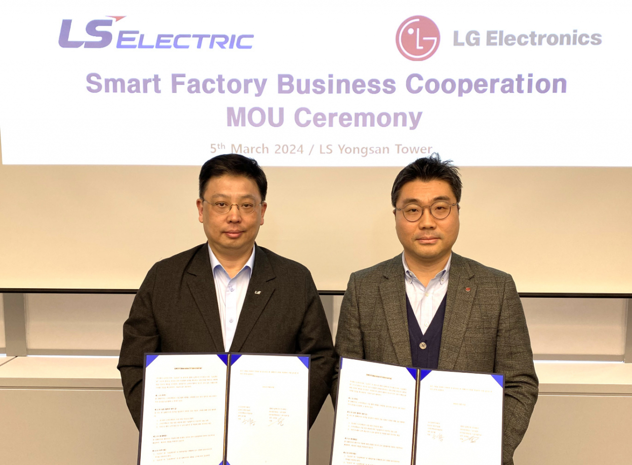 LS Electric senior vice president Cho Wook-dong (left) and LG Electronics vice president Song Si-yong(right) pose for a photo after signing MOU at LS Electric's headquarters in Yongsan, Seoul on Tuesday. (LS Electric)