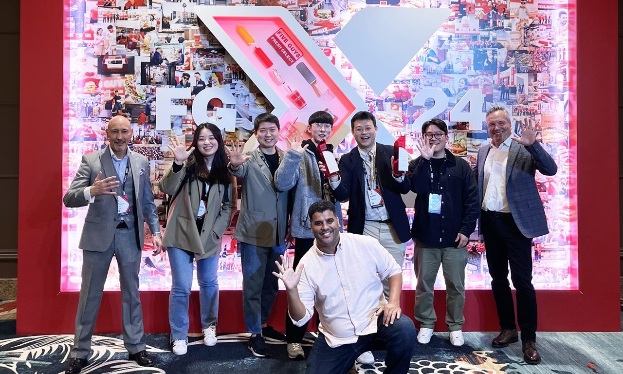 FG Korea CEO Oh Min-woo (third from left) and FG Korea officials join Five Guys representatives for a photo at the Five Guys Conference in Las Vegas. (FG Korea)