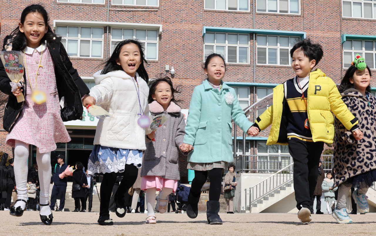Children run to their parents after an admission ceremony at Galsan Elementary School in Seoul on Monday. (Yonhap)