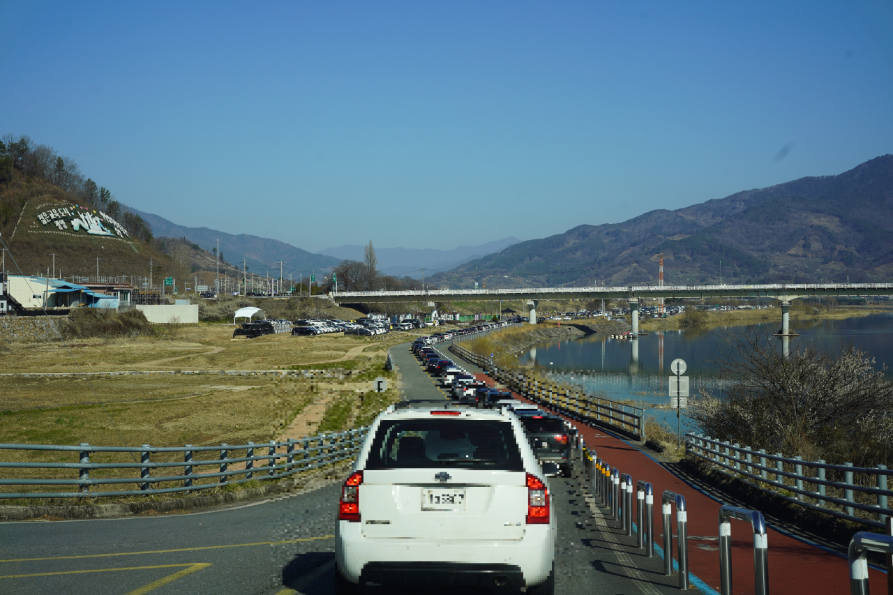 A long line of cars wait to enter Dunchi parking lot at Gwangyang on Saturday. (Lee Si-jin/The Korea Herald)