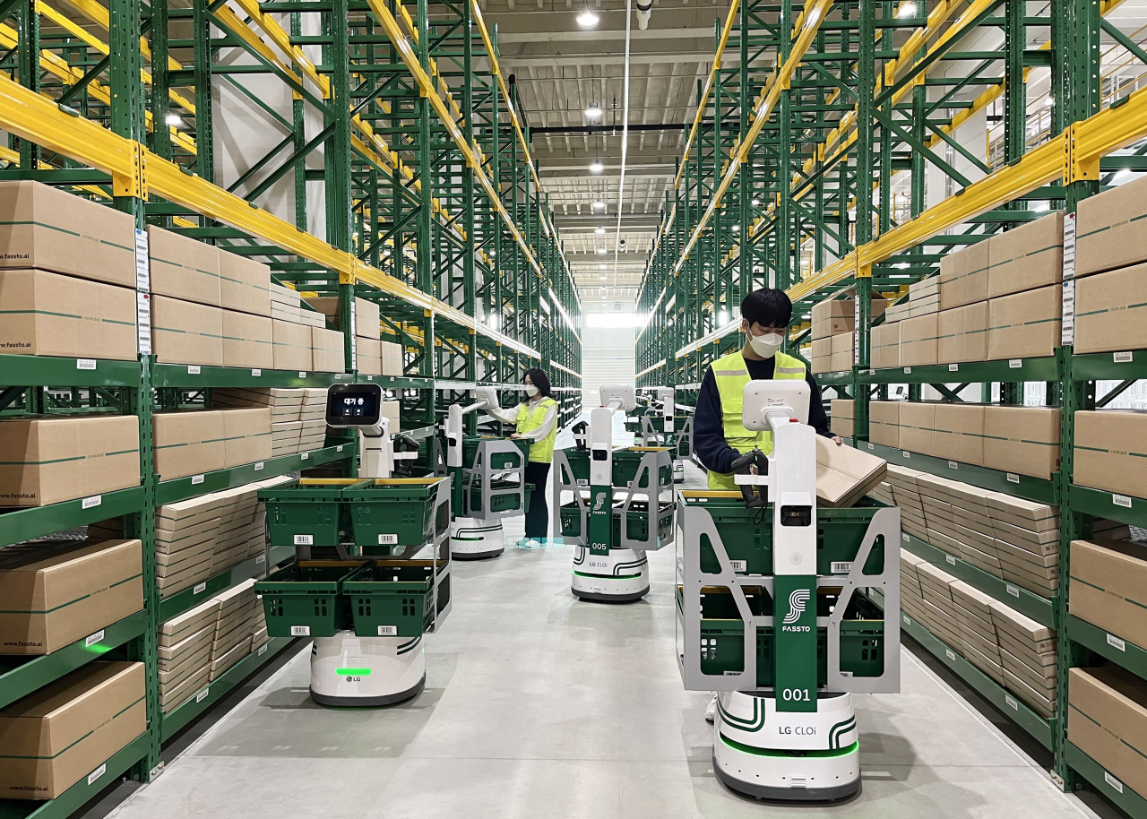 Employees organize boxes with LG CLOi Carrybot in Fassto's smart logistics center in Yongin, Gyeonggi Province. (LG Electronics)